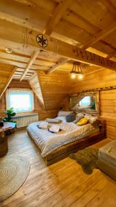 - une chambre avec un grand lit dans une cabane en bois dans l'établissement Gorący Potok Apartamenty, à Szaflary