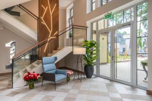 un hall avec un escalier et une chaise bleue dans l'établissement STORIES Design ApartHotel, à Jurmala