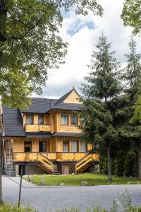 una grande casa in legno con tetto nero di Apartamenty Villowe - Zakopane Centrum a Zakopane