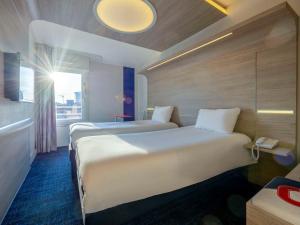 Cama ou camas em um quarto em ibis Styles La Rochelle Centre