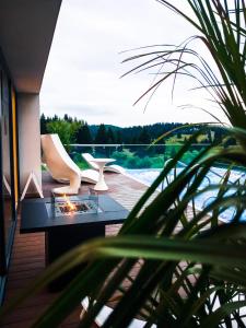 a living room with a table and chairs on a deck at Elexus Apartments Poiana Brasov in Poiana Brasov