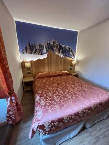 ein Schlafzimmer mit einem Bett mit einem Wandbild der Berge in der Unterkunft Hotel Des Glaciers in Courmayeur