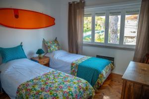 1 dormitorio con 2 camas y ventana en Moby Dick Lodge Colares, en Colares