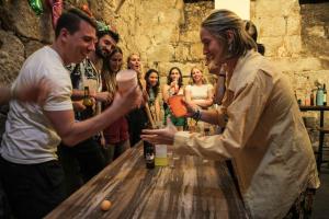 eine Gruppe von Menschen, die um einen Tisch mit einer Flasche Wein stehen in der Unterkunft Onefam Ribeira in Porto