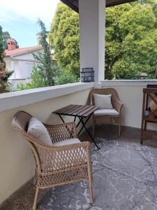 - une terrasse couverte avec 2 chaises, une table et 2 fenêtres dans l'établissement Vintage Villa Magnolia, à Pula