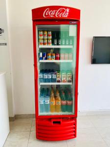 ein alter Kühlschrank mit Cola Soda und offener Tür in der Unterkunft Hostel Meio do Mundo in Macapá