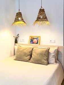 - une chambre avec un lit et deux lumières au-dessus dans l'établissement Beach & Castle - Sines Apartment, à Sines