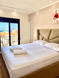 a bedroom with a large white bed with a balcony at Fimi Apartments in Ulcinj