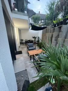 une terrasse avec une table en bois, des chaises et des plantes dans l'établissement Stilvolle 1-Zimmer Wohnung mit Terasse nahe Therme und Prezero Arena, à Sinsheim