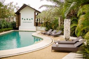 a swimming pool with lounge chairs next to a building at Ratan Uluwatu Hotel and Villas in Uluwatu