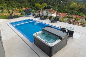 una piscina con vasca idromassaggio accanto a una casa di Quinta Flor de Lis, Gerês a Vieira do Minho