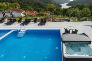 una grande piscina blu con vista sul fiume di Quinta Flor de Lis, Gerês a Vieira do Minho