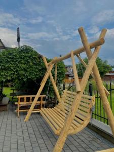 una panca di legno seduta in cima a un patio di Pokoje z własnymi aneksami kuchennymi - Zbigniew Lassak a Biały Dunajec