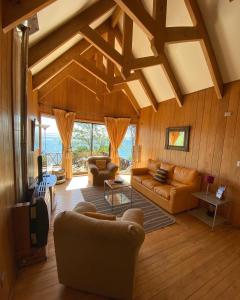 sala de estar con sofá y TV en Cabañas Bahia Celeste, Puerto Varas, en Puerto Varas