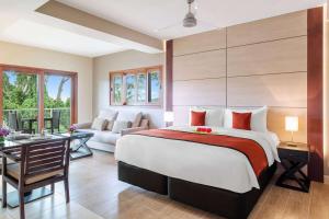 um quarto com uma cama grande e uma sala de estar em Ramada Resort by Wyndham Port Vila em Port Vila