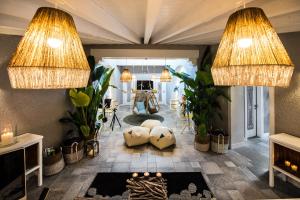 a living room with two large lights and plants at CapoBlu Hotel in Pula