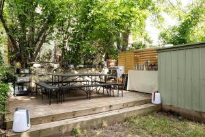 um pátio com uma mesa e cadeiras num deque de madeira em Charmant Appartement avec Jardin em Suresnes