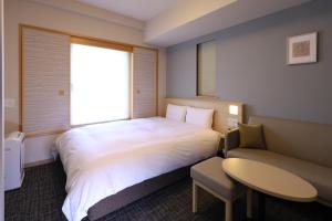 A bed or beds in a room at Dormy Inn Premium Ginza