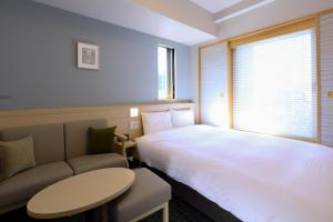 A bed or beds in a room at Dormy Inn Premium Ginza