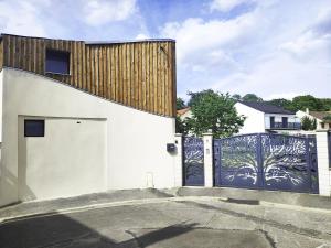 a white building with a gate with a tree painted on it at Sara in Aulnay-sous-Bois