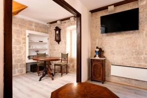 a living room with a table and a tv on a wall at Golubica in Stari Grad