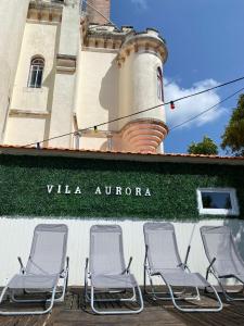 un groupe de chaises assises à l'extérieur d'un bâtiment avec phare dans l'établissement Vila Aurora, à Luso