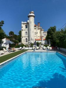 - une piscine en face d'un bâtiment avec un château dans l'établissement Vila Aurora, à Luso