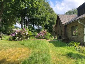 una casa con un giardino con erba e fiori di Le refuge de Kila a Waimes