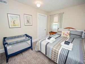 Un dormitorio con una cama azul con toallas. en The Cherry St House near Missouri State University, en Springfield