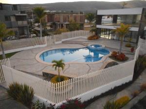 Hermosa Casa en Orilla del lago -Zona de villedos- في San Cristóbal Zapotitlán: مسبح كبير وحوله سياج أبيض