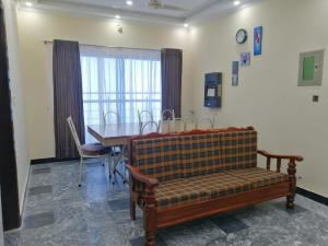 a dining room with a table and a couch and a table and chairs at Navid's Holiday Resort and Hotel, Murree in Ghora Gali