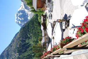 uma vista para uma montanha a partir de uma rua com flores em Hotel du Pigne em Arolla