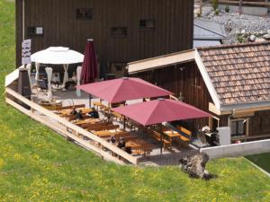 a restaurant with tables and umbrellas on a building at stettli resort in Parpan