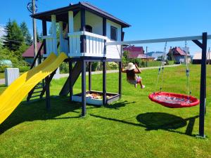 un bambino che gioca in un parco giochi con scivolo di Stylovy a Białka