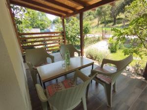 un tavolo e sedie su un portico con vista su un campo di Apartment Serenity a Ohrid