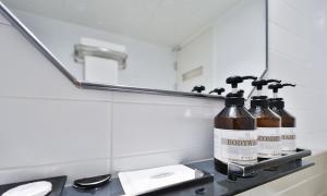 a bathroom sink with two bottles on a counter in front of a mirror at Haeundae Dongbeck Hotel in Busan