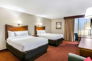 a hotel room with two beds and a desk at Clarion Hotel BWI Airport Arundel Mills in Hanover