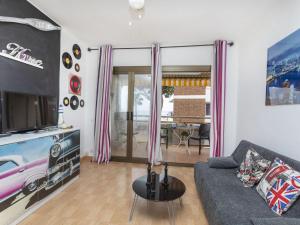 ein Wohnzimmer mit einem Sofa und einem TV in der Unterkunft Apartment MemLing-3 by Interhome in Vilafortuny