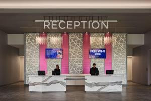 dos personas sentadas en una recepción en un vestíbulo en Great Canadian Casino Resort Toronto, en Toronto