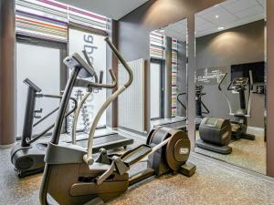 a gym with two tread machines and a mirror at Aparthotel Adagio Köln City in Cologne