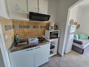 una piccola cucina con lavandino e forno a microonde di Standart Apartments , Glyfada Beach a Glifada (Glyfada)