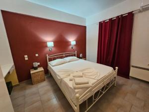 una camera con un letto con una parete rossa di Standart Apartments , Glyfada Beach a Glifada (Glyfada)