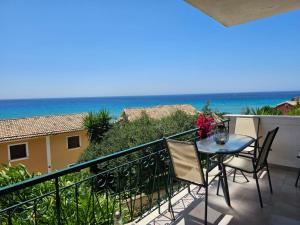 balcone con tavolo, sedie e vista sull'oceano di Standart Apartments , Glyfada Beach a Glifada (Glyfada)