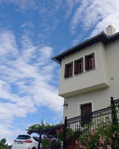 uma casa branca com duas janelas e um carro em Olga Studios em Tsagarada