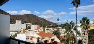 vista su una città con palme e edifici di Alsina Suite!! Hermoso y moderno apart en Salta!! a Salta