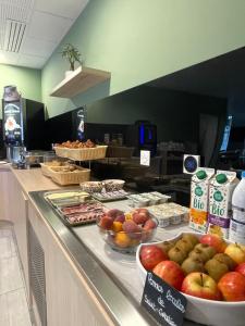 um buffet com maçãs e outros alimentos num balcão em The Originals Boutique Hôtel Amiens Sud em Amiens