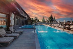 einen großen Pool mit Liegestühlen und Sonnenuntergang in der Unterkunft Katarino SPA Hotel in Bansko