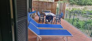 une table bleue et des chaises sur un balcon dans l'établissement Casa Vacanze O'Mulin Ravello via fiume 2 incrocio Pontone, à Ravello