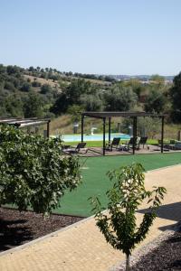 un pabellón con bancos y mesas en un campo verde en Aires da Serra Hotel, en Torres Novas