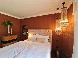 a bedroom with a white bed and two chandeliers at Rosendomizil Klein Venedig in Malchow